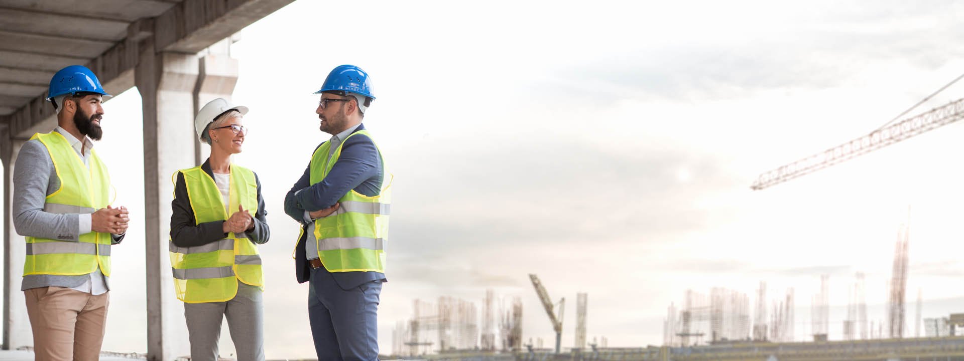 Sachverst&auml;ndige mit Helmen und Warnwesten besprechen eine Baustelle vor Ort